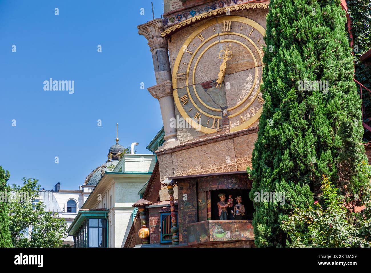 Der schiefe Uhrenturm des Gabriadze Puppentheaters befindet sich in Tiflis, Georgien. Eine goldene Uhr mit römischen Ziffern ist am Turm angebracht. Darunter befinden sich animierte Figuren, die zur Stunde erscheinen. Tiflis, Georgien Stockfoto