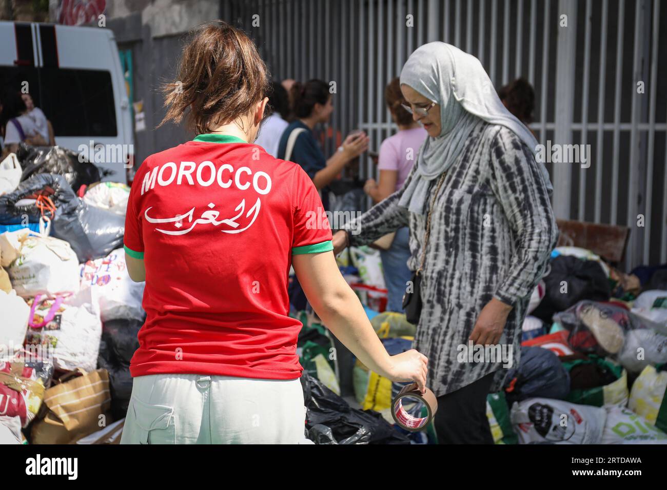 Madrid, Spanien. September 2023. Ein Nachbar, der ein marokkanisches Fußballtrikot trägt, hilft beim Sammeln von Spenden auf dem Sportplatz im Stadtteil Lavapies in Madrid. Anonyme Menschen aus dem Viertel Lavapiés haben sich organisiert, um Kleidung und Essen für die von dem Erdbeben, das Marokko erschüttert hat, in den Gebieten in der Nähe von Marrakesch zu geben.Ein paar Lastwagen mit Spenden, die direkt von Madrid nach Marokko reisen werden. Quelle: SOPA Images Limited/Alamy Live News Stockfoto