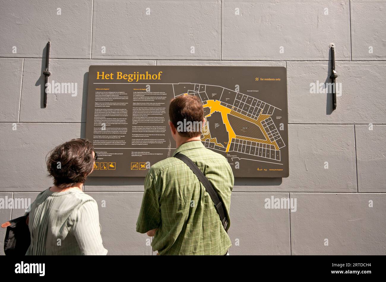 Touristen, die sich die Karte am Eingang des Begijnhofs, Amsterdam, Niederlande ansehen Stockfoto