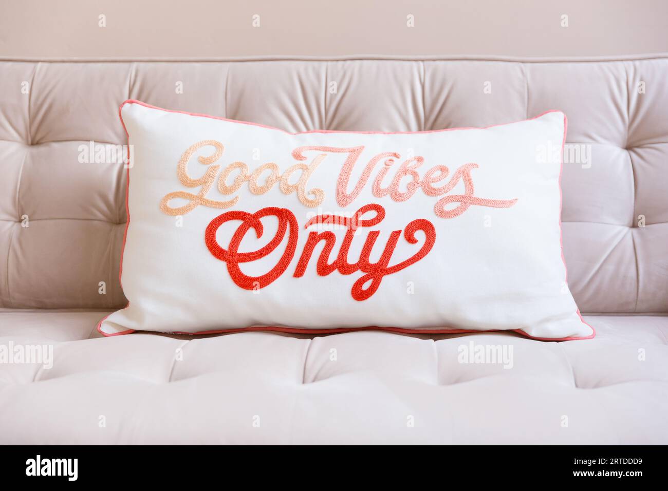 Nahaufnahme eines guten Vibes nur Kissen auf einem blassrosa Sofa mit Platz für Text Stockfoto