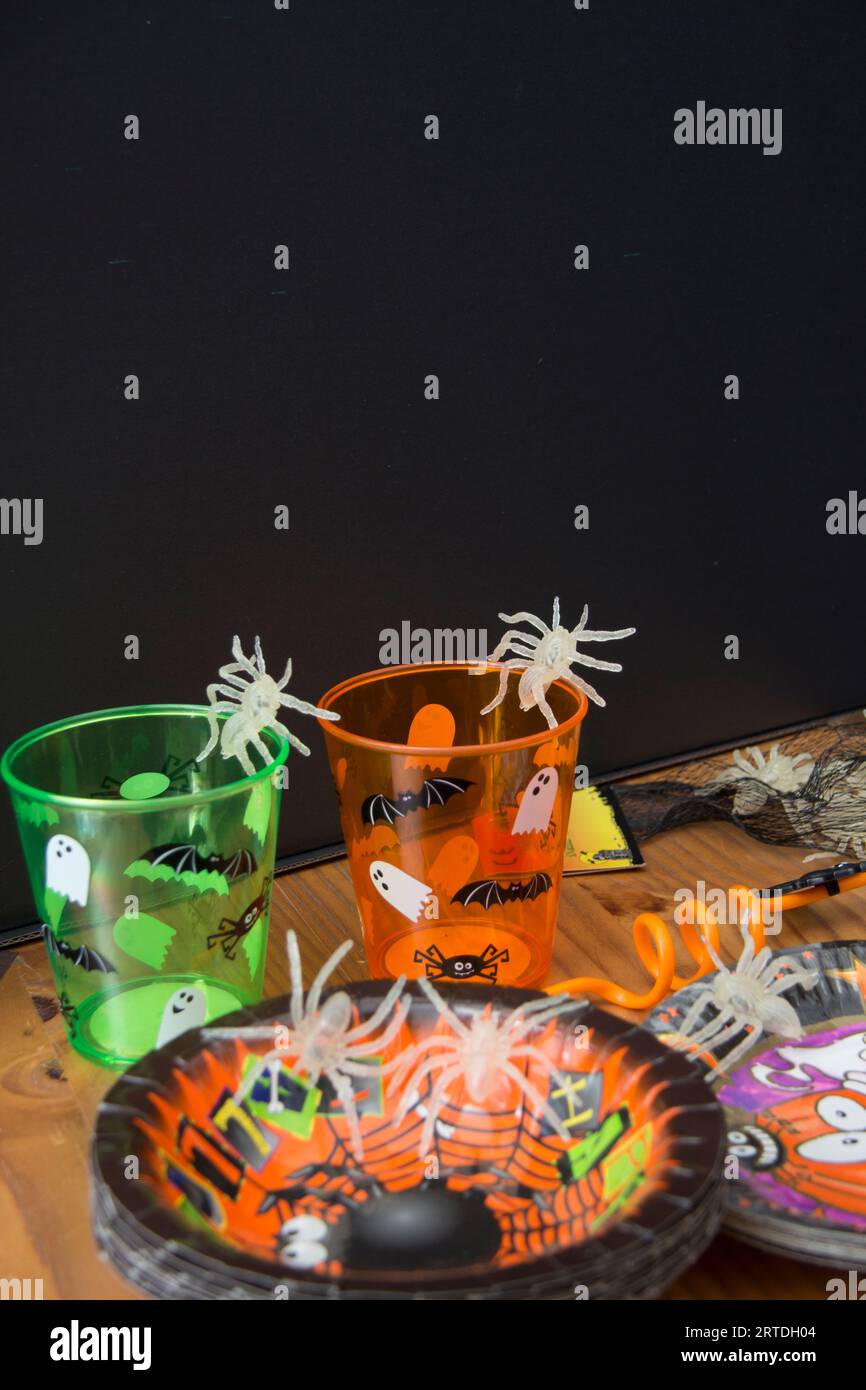Halloween-Party-Tisch mit Tassen, Geschirr und Krabbelinsekten in der Nacht Stockfoto