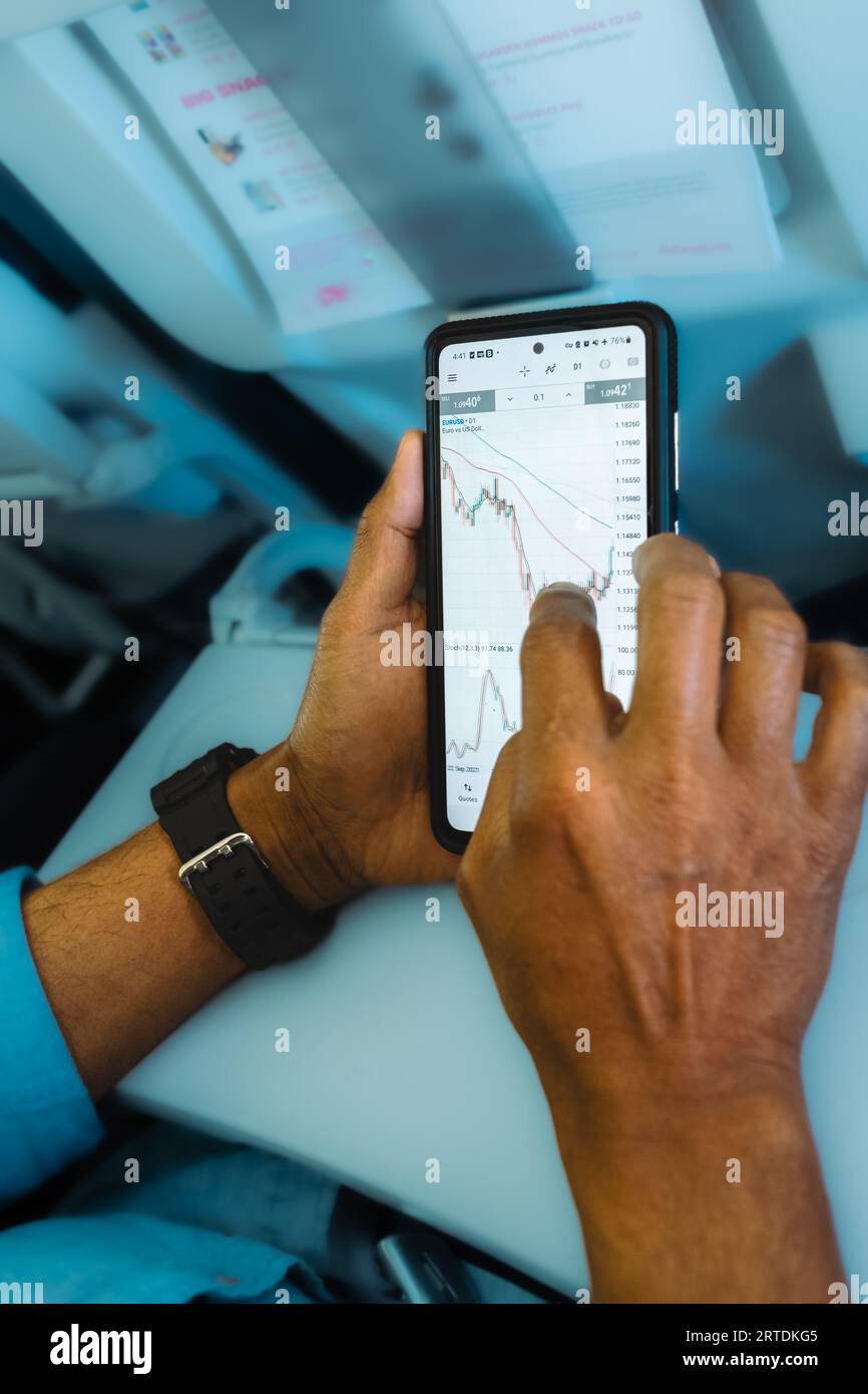Mann, der den Devisenmarkt auf dem Smartphone überprüft. Mobile Stock Phone-Anwendung. Finanzbörse und -Handel. Händler, der Smartphone mit Börseneinsätzen verwendet Stockfoto