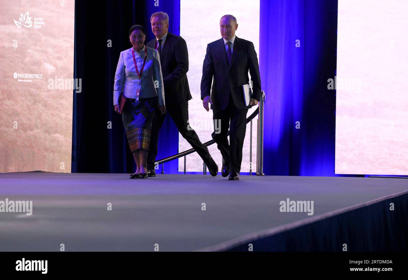 Wladiwostok, Russland. September 2023. Der russische Präsident Wladimir Putin, rechts, laotischer Vizepräsident Pany Yathotou kommen auf der Bühne der Plenarsitzung des Östlichen Wirtschaftsforums 2023 an der Far Eastern Federal University auf der Insel Russki am 12. September 2023 in Wladiwostok, Russland. Kredit: Mikhail Metzel/Kreml Pool/Alamy Live News Stockfoto