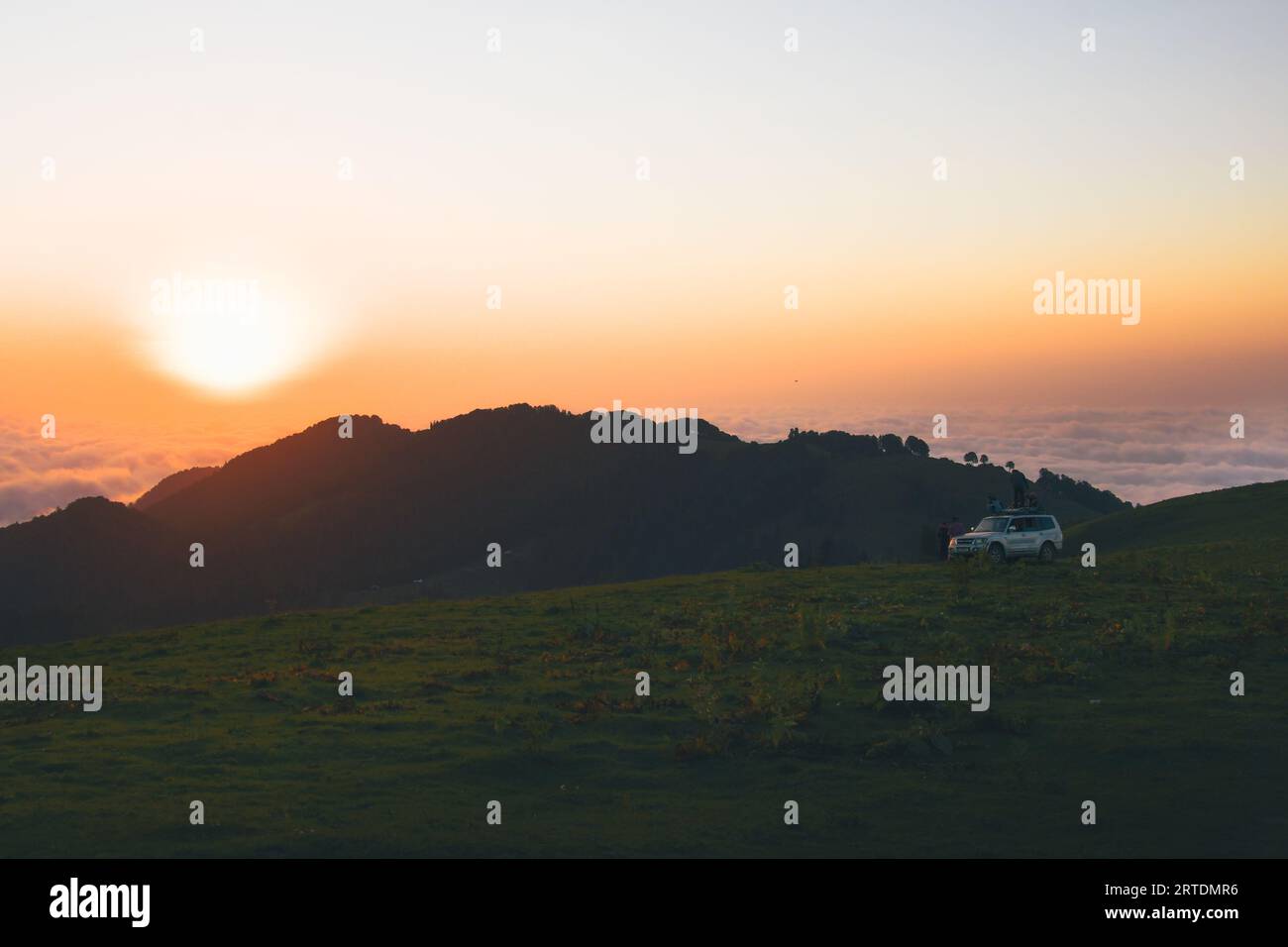 Akhmaro, Georgia - 14. august, 2022: Statische Ansicht Freunde Tour Gruppe Stand auf 4WD Dach beobachten Sonnenuntergang gemeinsam im Freien viel Spaß über Wolken in Famo Stockfoto