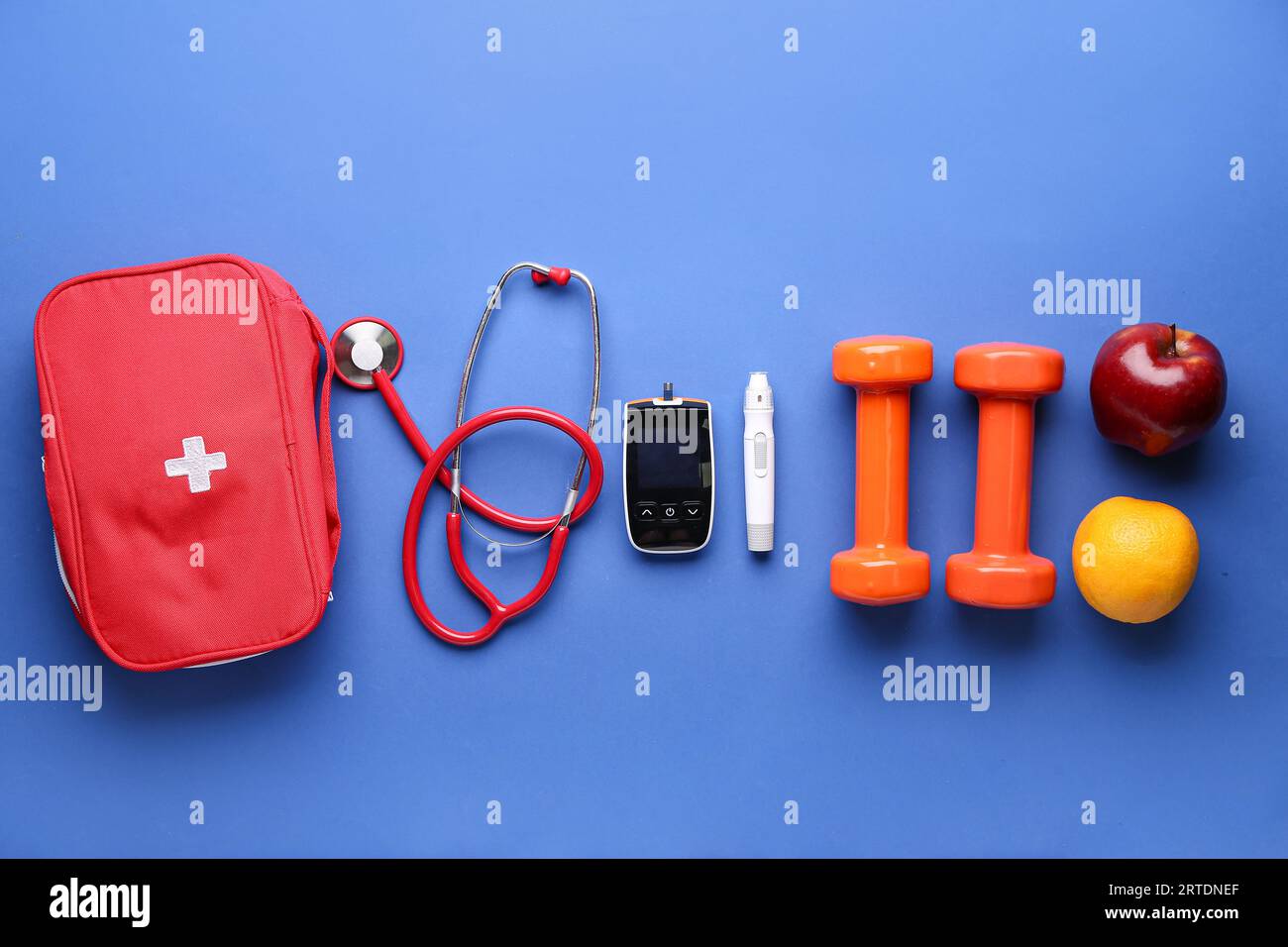 Glucometer, Kurzhanteln, Früchte, Stethoskop und erste-Hilfe-Set auf blauem Hintergrund. Diabetes-Konzept Stockfoto