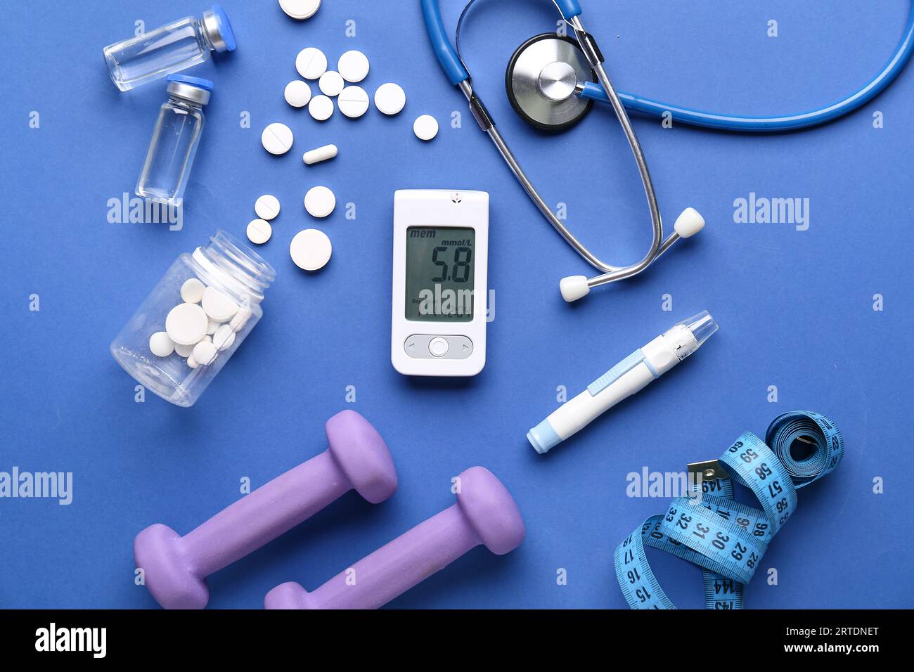 Zusammensetzung mit Glucometer, Lanzette, Medizin und Kurzhanteln auf blauem Hintergrund. Diabetes-Konzept Stockfoto