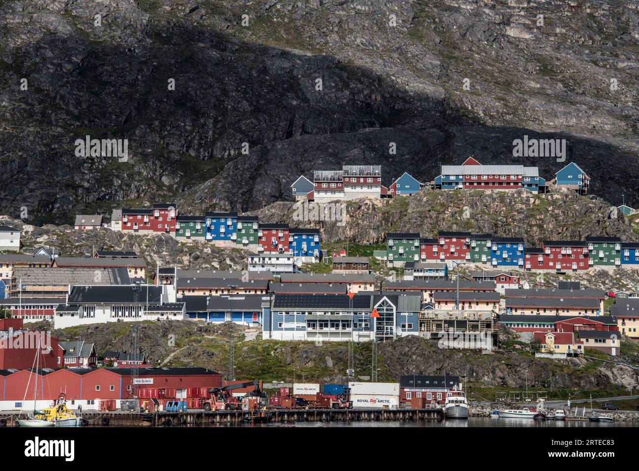 Farbenfrohe Gebäude an den felsigen Klippen entlang der Küste in der Stadt Qaqortoq an Grönlands Südspitze; Qaqortoq, Südgrönland, Grönland Stockfoto