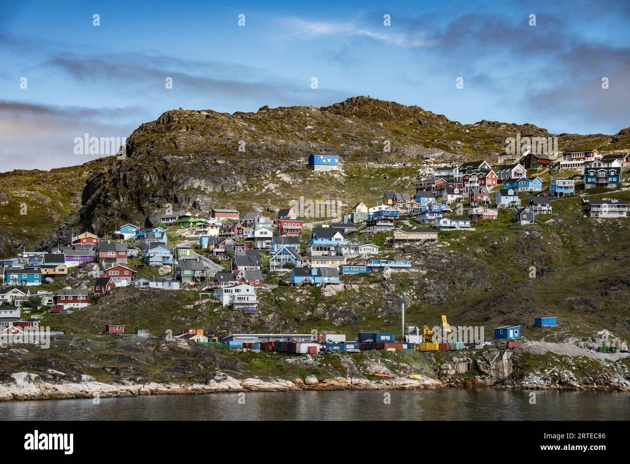 Farbenfrohe Häuser auf dem felsigen Hügel entlang der Nordatlantikküste in der Stadt Qaqortoq an Grönlands Südspitze Stockfoto