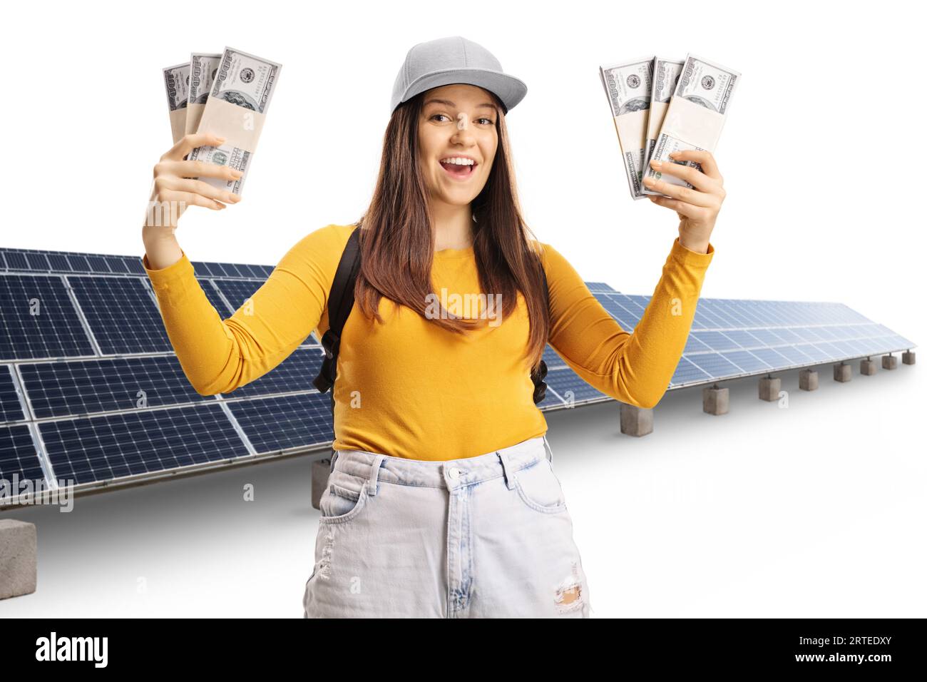Junge lächelnde Studentin, die Geldstapel vor Photovoltaik auf weißem Hintergrund hält Stockfoto