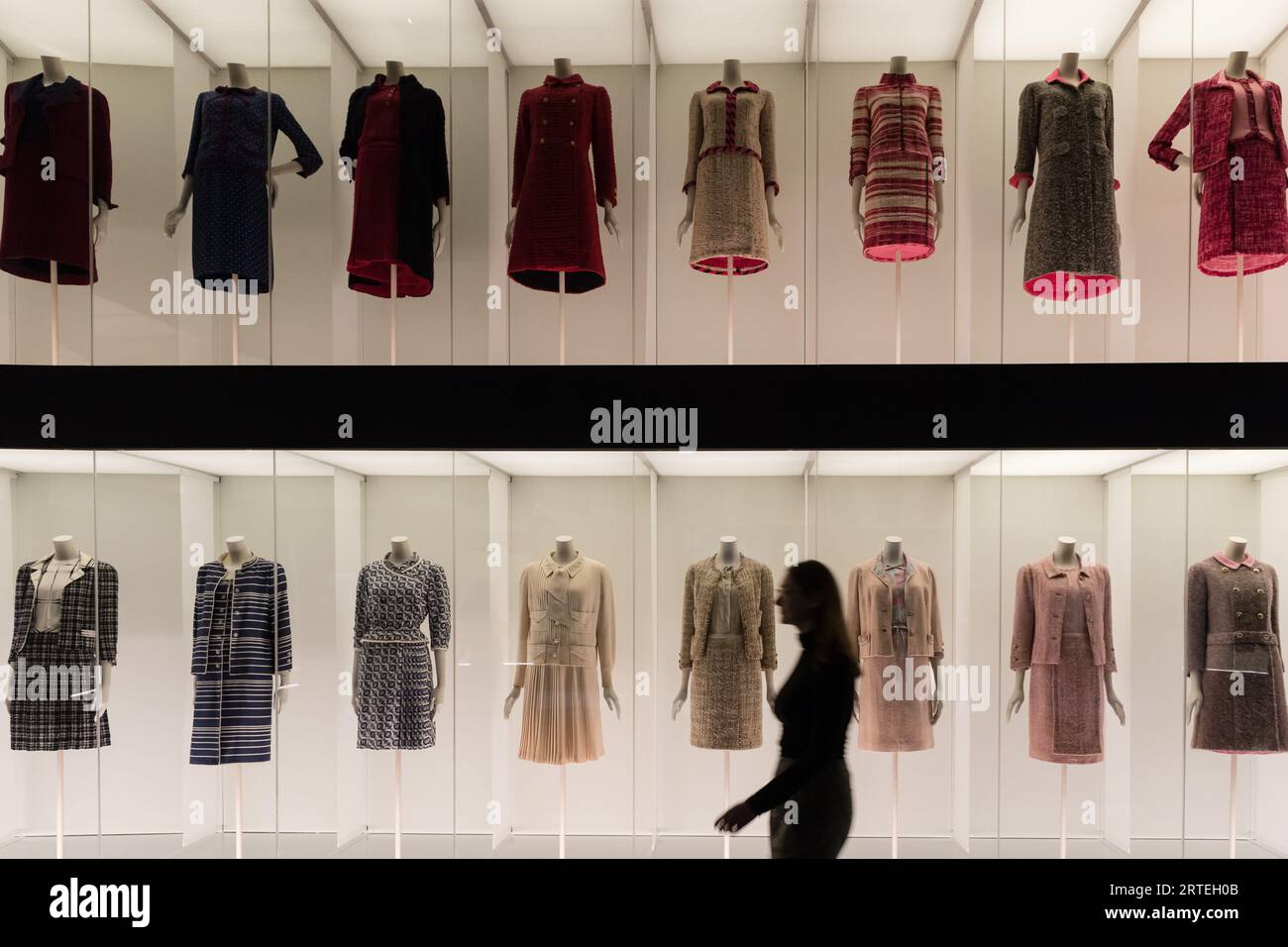 LONDON, VEREINIGTES KÖNIGREICH - 12. SEPTEMBER 2023: Ein Mitarbeiter spaziert während eines Fotogesprächs zur bevorstehenden Ausstellung Gabrielle Chanel an einem mehrstöckigen farbenfrohen Arrangement klassischer Chanel Tweedanzüge vorbei. Fashion Manifesto (16. September 2023 - 25. Februar 2024) bei der V&A in London, Großbritannien am 12. September 2023. Auf der ersten großen Ausstellung Großbritanniens, die der französischen Couturiere Gabrielle „Coco“ Chanel gewidmet ist, werden über 200 Looks, die zum ersten Mal zusammen gesehen werden, sowie Accessoires, Parfüms und Schmuck präsentiert. (Foto: Wiktor Szymanowicz/NurPhoto) Stockfoto