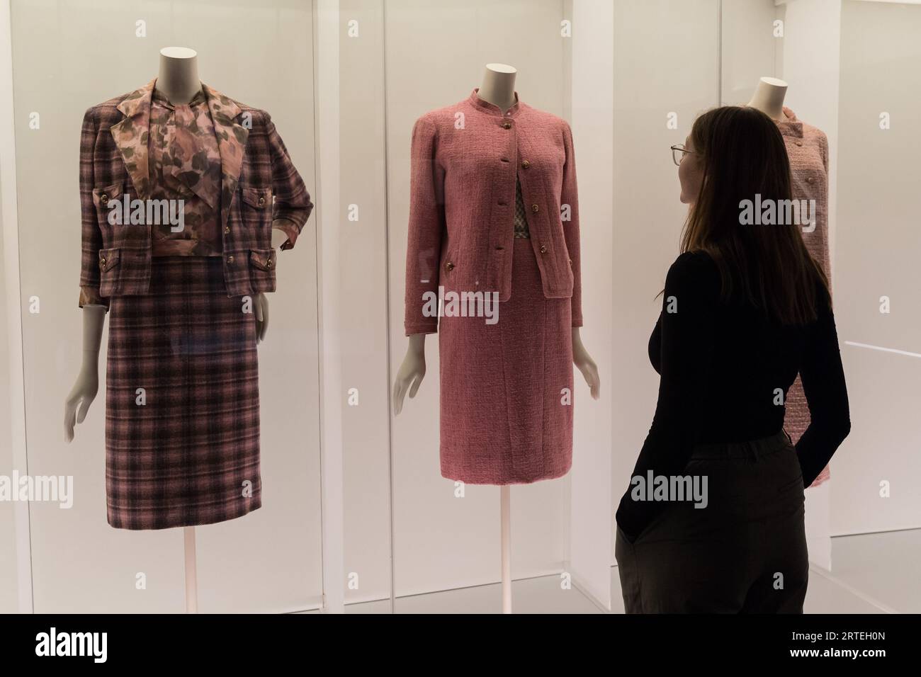 LONDON, VEREINIGTES KÖNIGREICH - 12. SEPTEMBER 2023: Ein Mitarbeiter betrachtet ein mehrstufiges farbenfrohes Arrangement klassischer Chanel Tweedanzüge während eines Fotorufs für die bevorstehende Ausstellung Gabrielle Chanel. Fashion Manifesto (16. September 2023 - 25. Februar 2024) bei der V&A in London, Großbritannien am 12. September 2023. Auf der ersten großen Ausstellung Großbritanniens, die der französischen Couturiere Gabrielle „Coco“ Chanel gewidmet ist, werden über 200 Looks, die zum ersten Mal zusammen gesehen werden, sowie Accessoires, Parfüms und Schmuck präsentiert. (Foto: Wiktor Szymanowicz/NurPhoto) Stockfoto