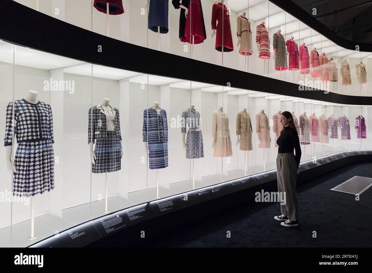 LONDON, VEREINIGTES KÖNIGREICH - 12. SEPTEMBER 2023: Ein Mitarbeiter betrachtet ein mehrstufiges farbenfrohes Arrangement klassischer Chanel Tweedanzüge während eines Fotorufs für die bevorstehende Ausstellung Gabrielle Chanel. Fashion Manifesto (16. September 2023 - 25. Februar 2024) bei der V&A in London, Großbritannien am 12. September 2023. Auf der ersten großen Ausstellung Großbritanniens, die der französischen Couturiere Gabrielle „Coco“ Chanel gewidmet ist, werden über 200 Looks, die zum ersten Mal zusammen gesehen werden, sowie Accessoires, Parfüms und Schmuck präsentiert. (Foto: Wiktor Szymanowicz/NurPhoto) Stockfoto