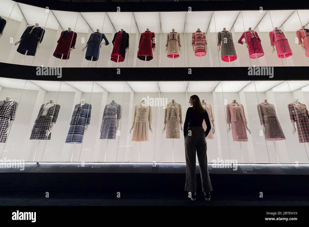 LONDON, VEREINIGTES KÖNIGREICH - 12. SEPTEMBER 2023: Ein Mitarbeiter betrachtet ein mehrstufiges farbenfrohes Arrangement klassischer Chanel Tweedanzüge während eines Fotorufs für die bevorstehende Ausstellung Gabrielle Chanel. Fashion Manifesto (16. September 2023 - 25. Februar 2024) bei der V&A in London, Großbritannien am 12. September 2023. Auf der ersten großen Ausstellung Großbritanniens, die der französischen Couturiere Gabrielle „Coco“ Chanel gewidmet ist, werden über 200 Looks, die zum ersten Mal zusammen gesehen werden, sowie Accessoires, Parfüms und Schmuck präsentiert. (Foto: Wiktor Szymanowicz/NurPhoto) Stockfoto