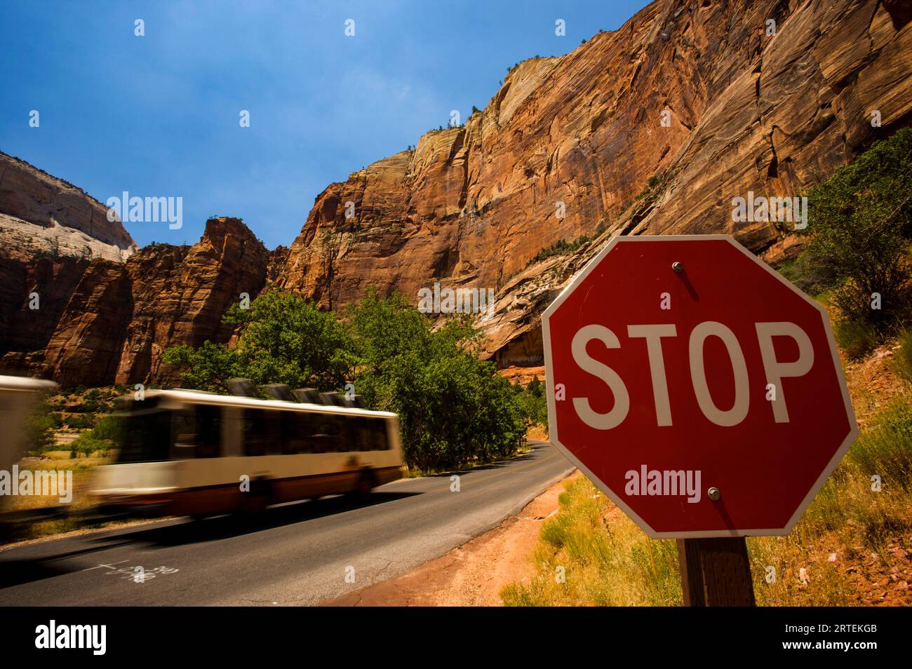 Propan-betriebener Shuttlebus passiert ein Stoppschild im Zion-Nationalpark; Utah, Vereinigte Staaten von Amerika Stockfoto