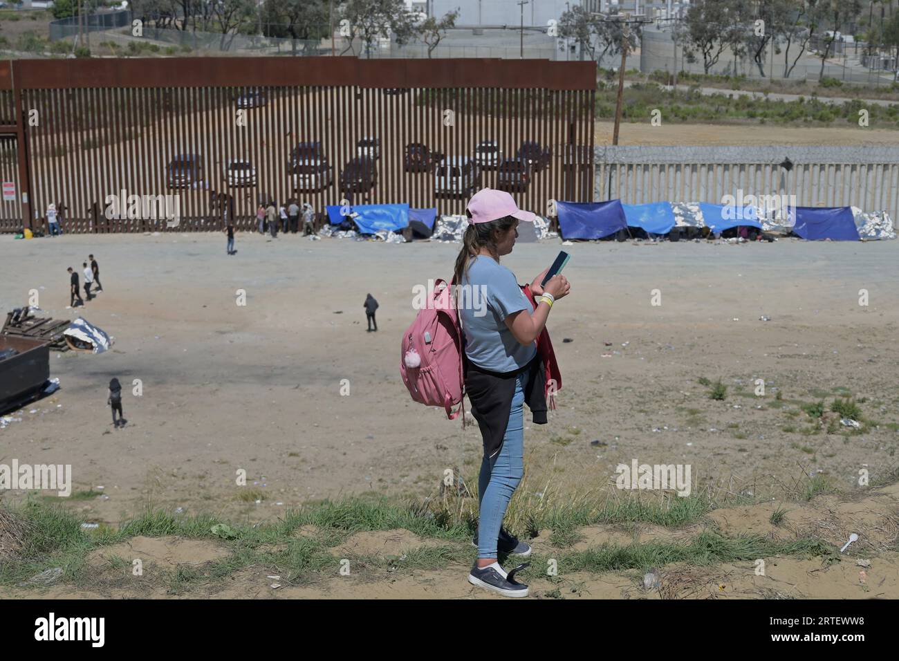 Tijuana, Baja California, Mexiko. September 2023. Am Dienstag, den 12. September 2023, sitzen etwa hundert Menschen zwischen den beiden Grenzzäunen zwischen den USA und Mexiko fest, die Tijuana und San Diego trennen, wie man von Tijuana aus gesehen hat. US-Beamte entlang der Grenze zu Mexiko verarbeiteten diesen Juli 183.000 plus Migranten, da illegale Überfahrten um 33 Prozent sprangen, nachdem sie im Juni auf ein zweijähriges tief gefallen waren, einen Monat, nachdem die Migrantenpolitik des Titels 42 am 12. Mai trotz Rekordwärmeniveaus aufgehoben wurde, laut Regierungsstatistiken. (Bild: © Carlos A. Moreno/ZUMA Press Wire) NUR REDAKTIONELLE VERWENDUNG! Nicht Stockfoto