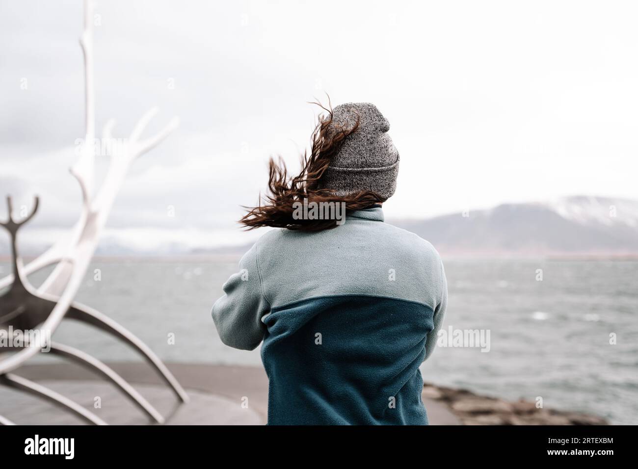Fesselnder Schuss einer Frau, die in Gedanken in den Horizont blickt, gegen die Weite des Meeres und des Himmels. Stockfoto