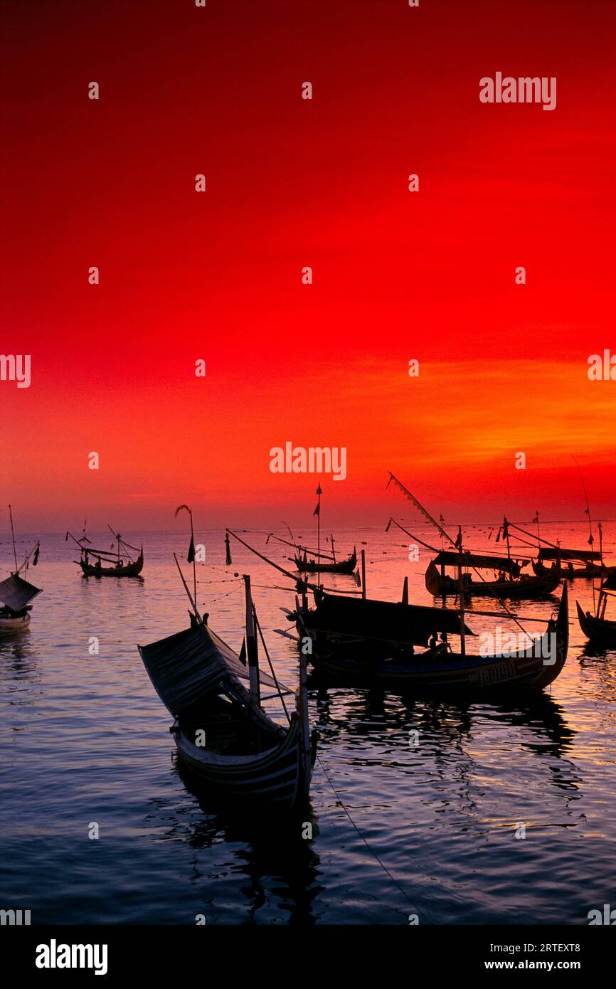 Indonesien, Bali, Jimbaran Bay, Mit Vielen Fischerbooten Vor Anker, Red Sunset Sky Stockfoto