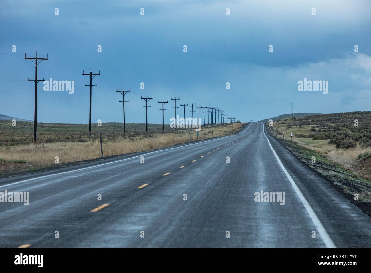 USA, Nevada, McDermitt, Strommasten entlang der Autobahn bei stürmischem Wetter Stockfoto