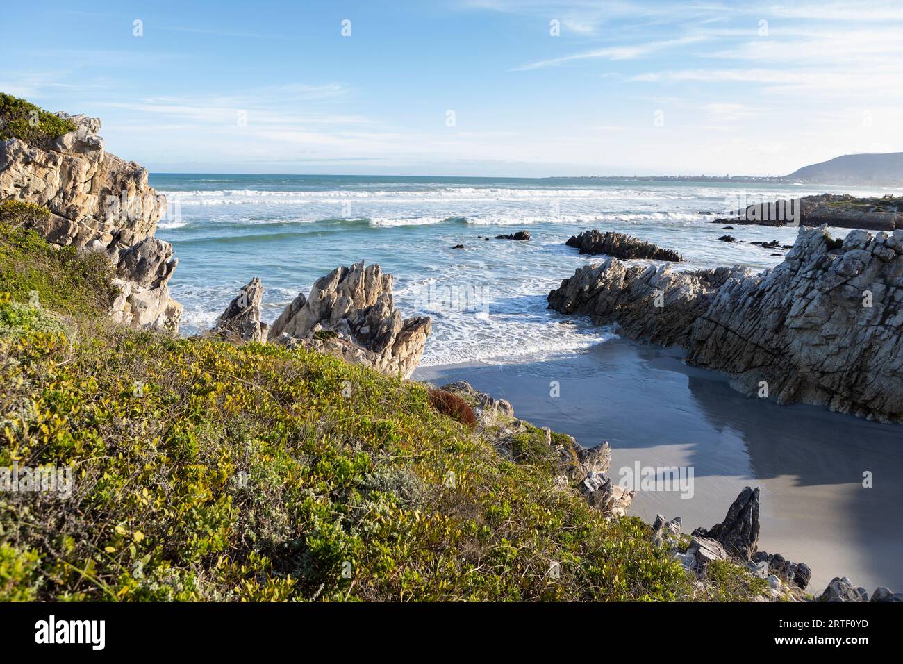 Südafrika, Hermanus, felsige Küste mit Atlantik am Voelklip Beach an sonnigen Tagen Stockfoto