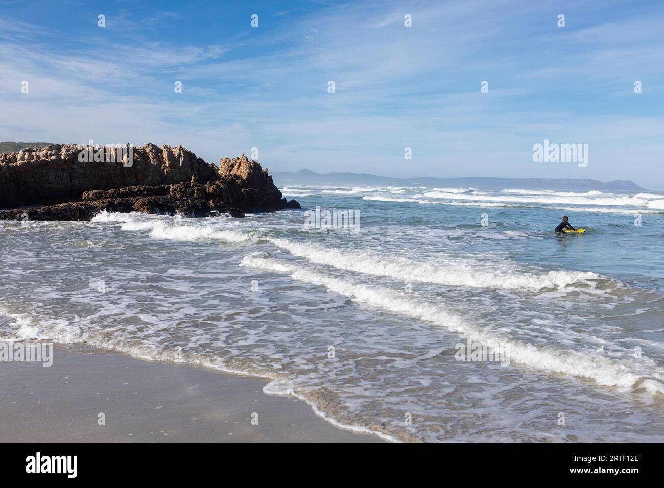 Südafrika, Hermanus, Boy (10-11) Bodyboarding im Atlantik am Kammabaai Beach Stockfoto