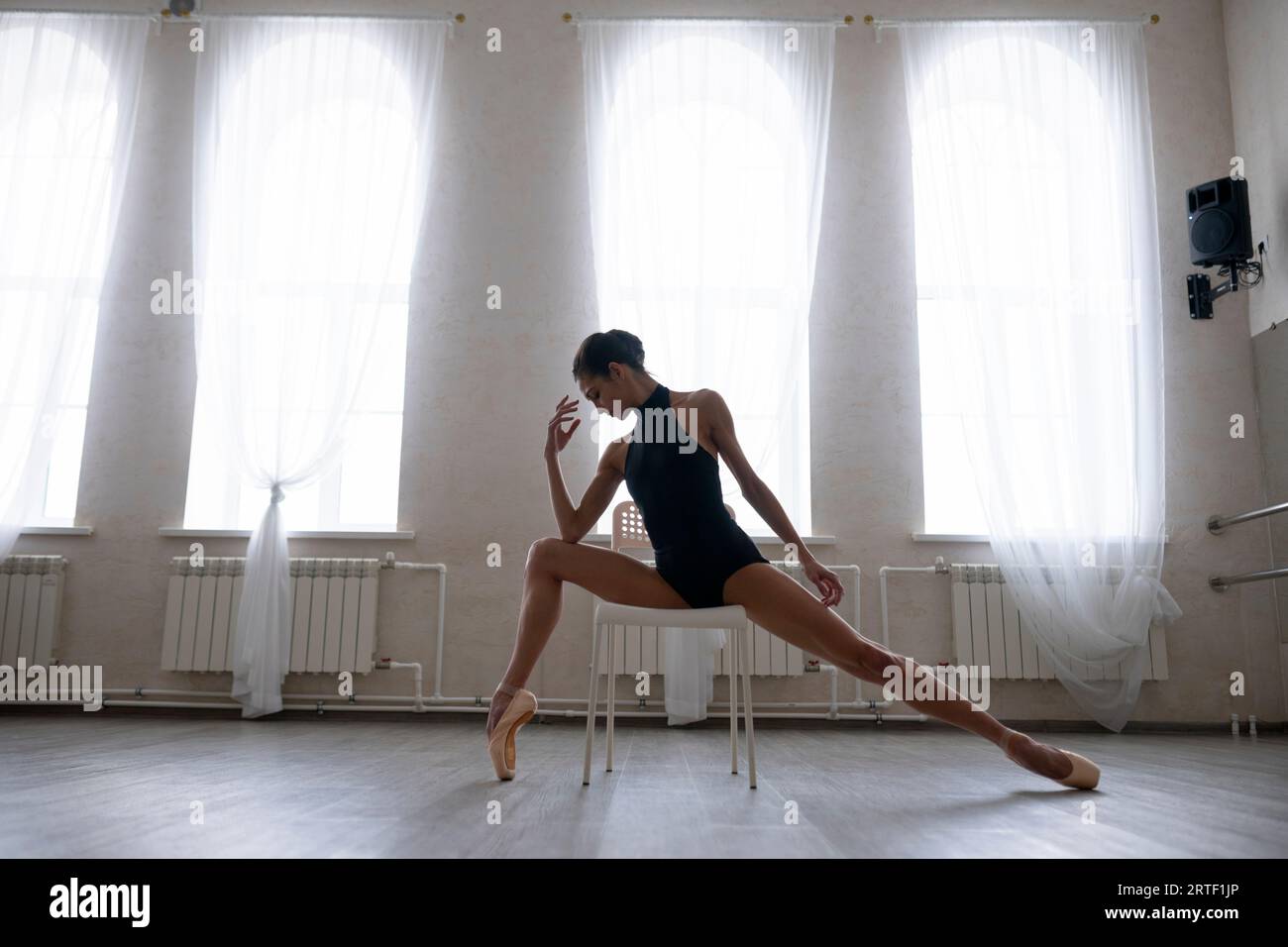 Ballerina, die auf Stuhl im Tanzstudio übt Stockfoto