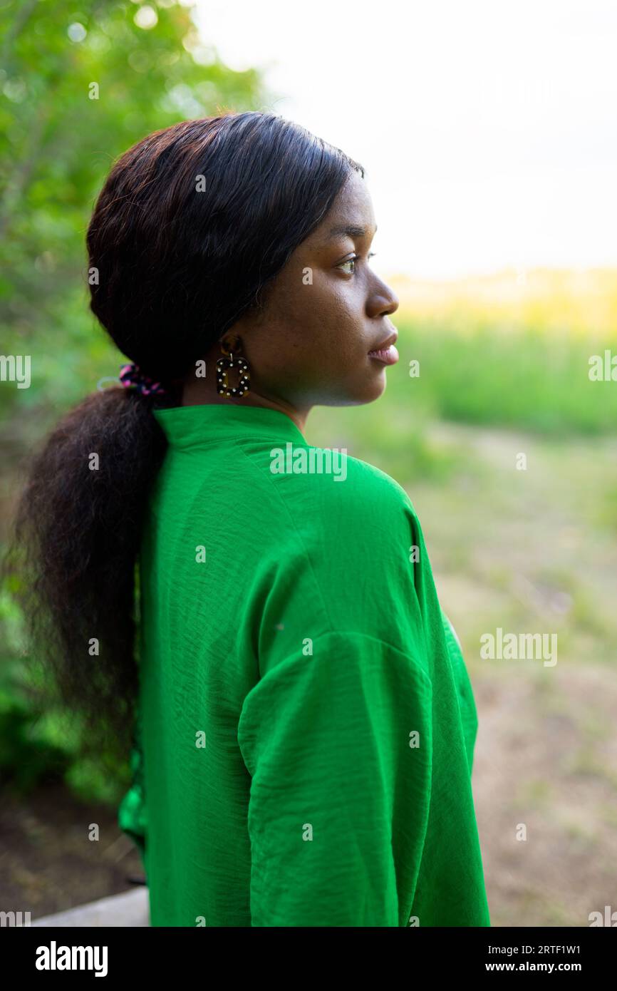 Seitenansicht einer brünetten Frau mit grüner Bluse Stockfoto