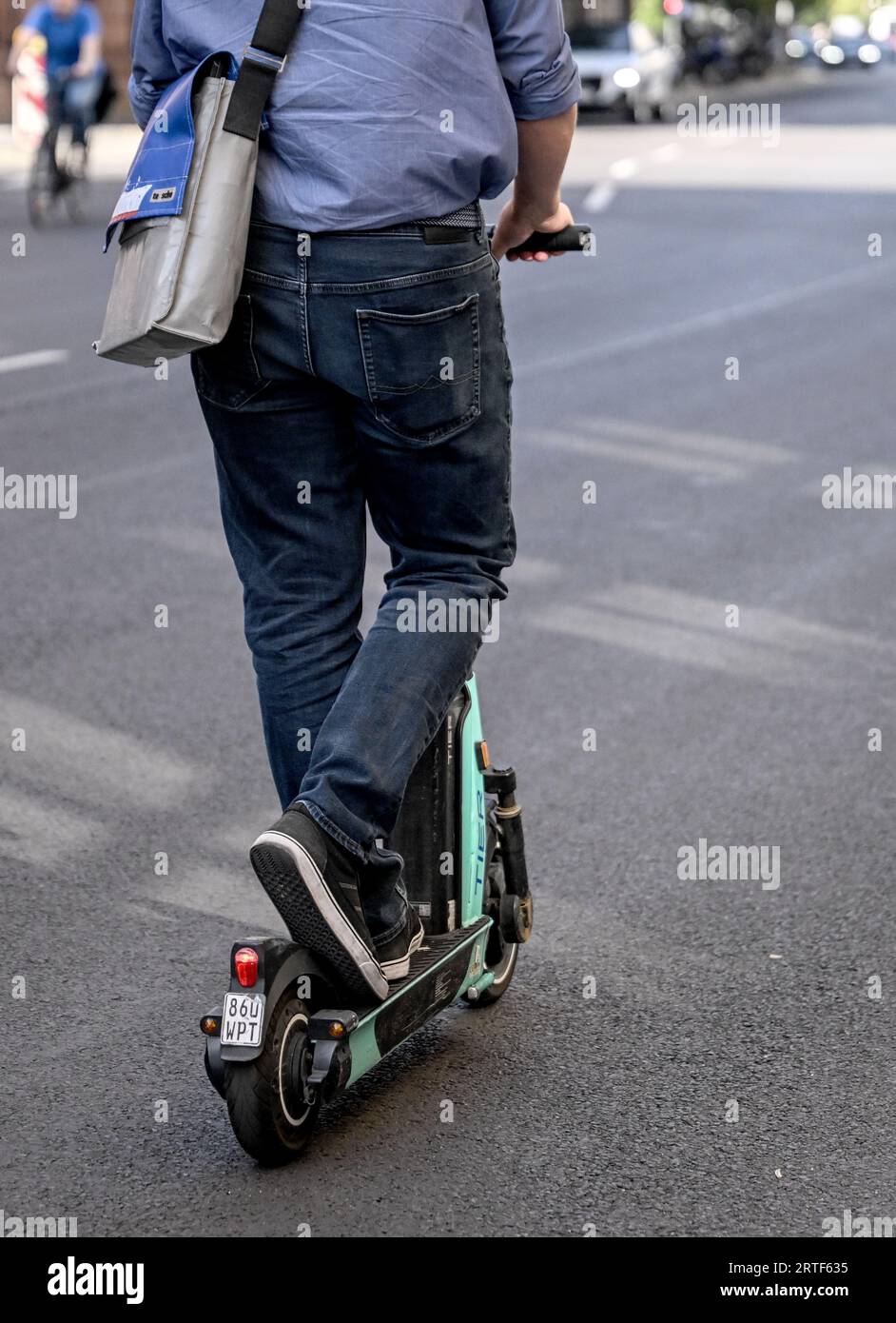 Berlin, Deutschland. September 2023. Ein junger Mann fährt auf der Straße mit einem E-Roller. Nur wenige benutzen E-Scooter, aber viele ärgern sich über die batteriebetriebenen Scooter - besonders in Großstädten. Quelle: Britta Pedersen/dpa/Alamy Live News Stockfoto