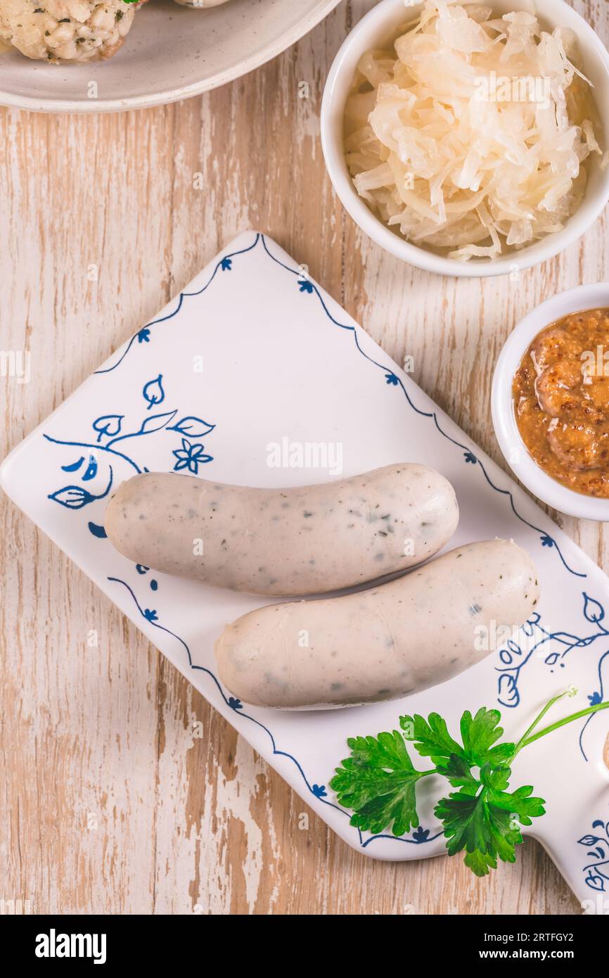 Bayerische Weißwürste mit Sauerkraut und Semmelknödeln, mit Senf. Stockfoto