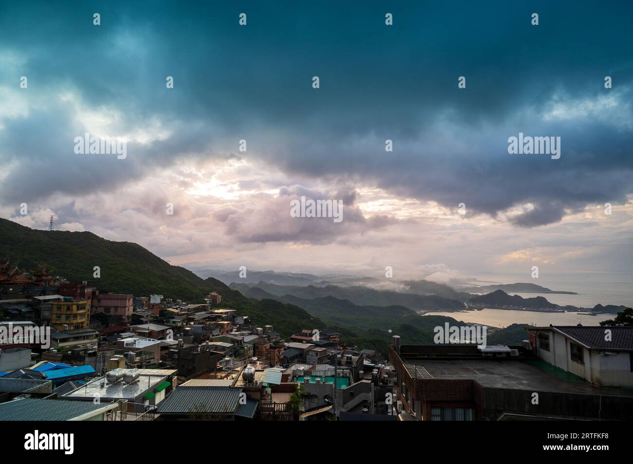 Schichten von Bergen und Wolken und Dörfern bilden zusammen ein Bild. Blick auf die Berge und das Meer vom Hochland des Ruifang District. Stockfoto