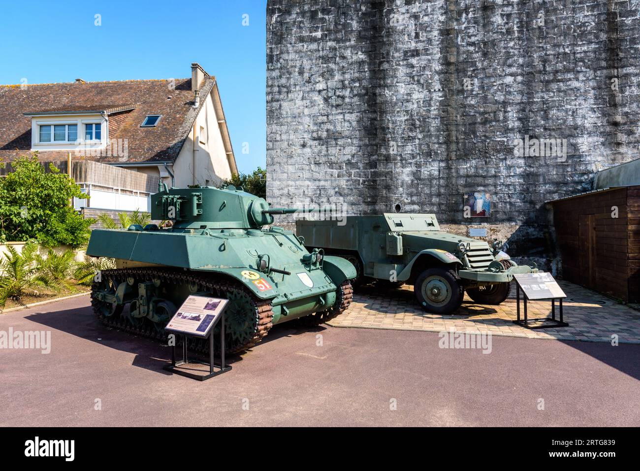 Ein M3 Stuart-Leichtpanzer und ein M3-Halbgleis außerhalb von „Le Grand Bunker“, einem ehemaligen deutschen Bunker, der in ein Museum der Atlantischen Mauer in Ouistreham umgewandelt wurde. Stockfoto