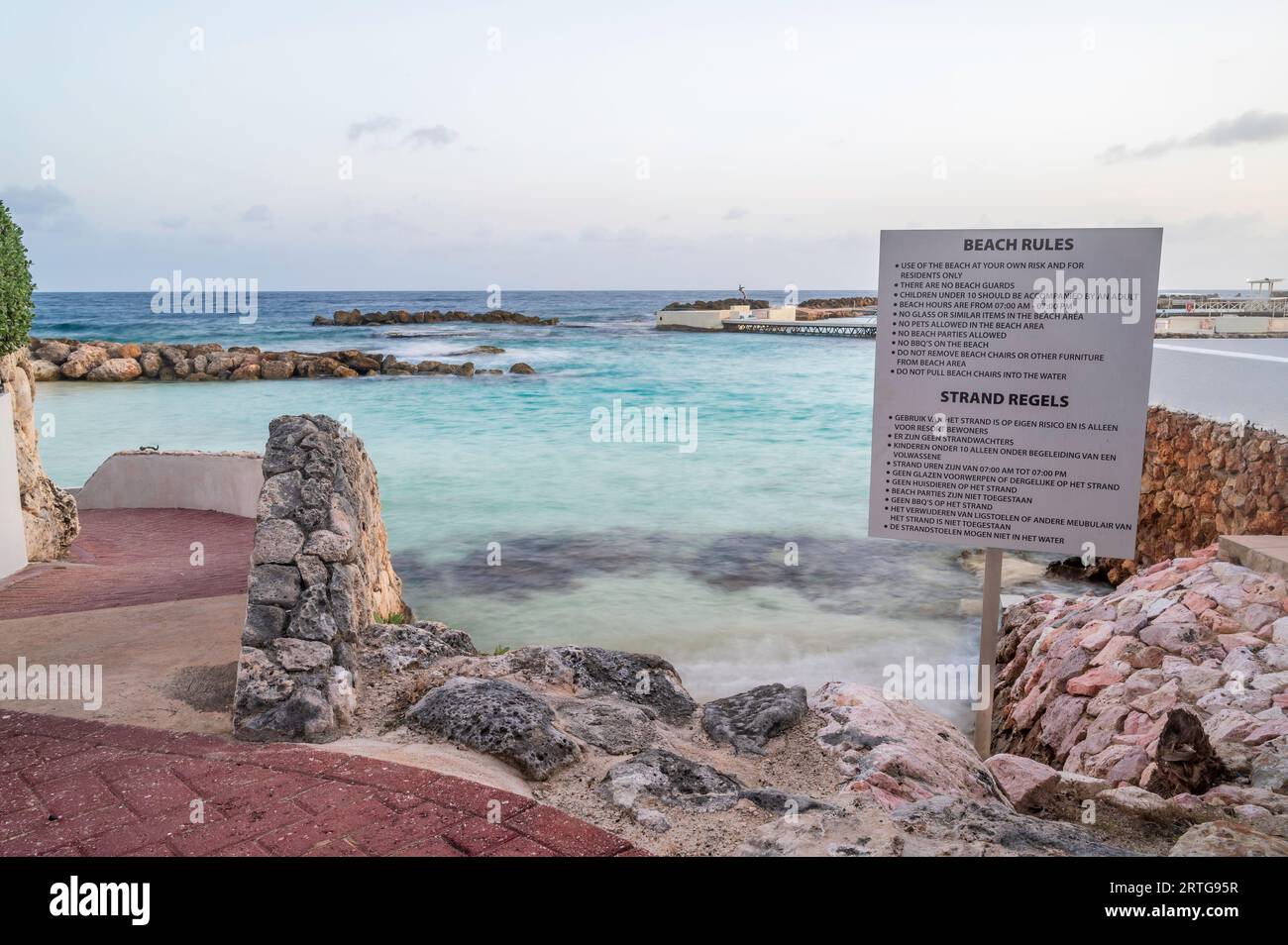 Ein Zeichen der Anweisungen an einer felsigen Küste eines Strandes auf einer tropischen Insel. Stockfoto
