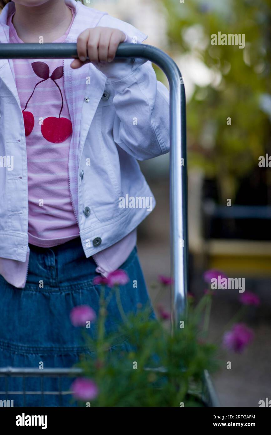 Junges Mädchen schob einen Wagen in ein Gartencenter Stockfoto