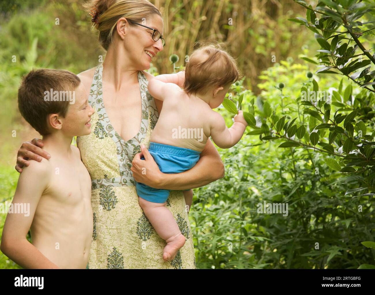 Familie steht in einem Garten umarmen Stockfoto