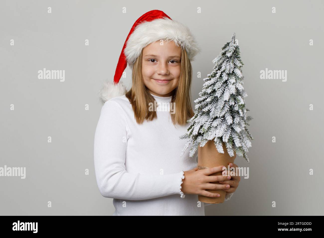 Kind Weihnachtsmann lächelt. Kleines Mädchen und Weihnachtsbaum. Xmas Kind 10 Jahre alt Stockfoto