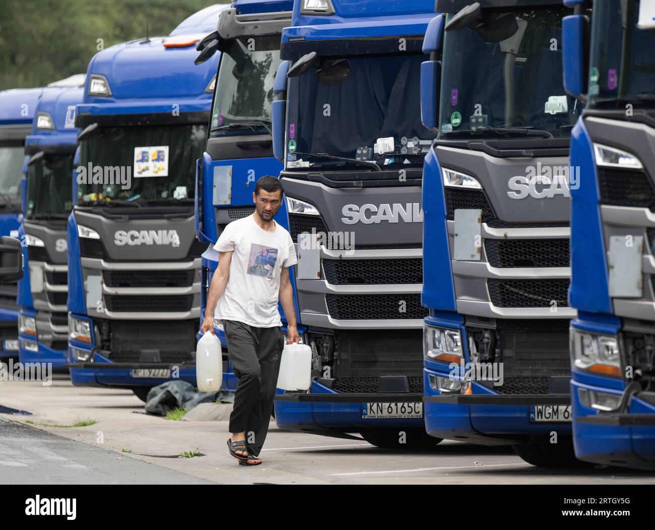 13. September 2023, Hessen, Gräfenhausen: Ein Lkw-Fahrer trägt Wasserkanister zu seinem Fahrzeug auf dem Parkplatz des Servicegebiets Gräfenhausen. Die aus mehreren osteuropäischen Ländern stammenden Fahrer warten seit fast zwei Monaten in ihren LKWs auf dem Parkplatz des Servicegebietes Gräfenhausen auf die Bezahlung ihrer Löhne. Foto: Boris Roessler/dpa Stockfoto