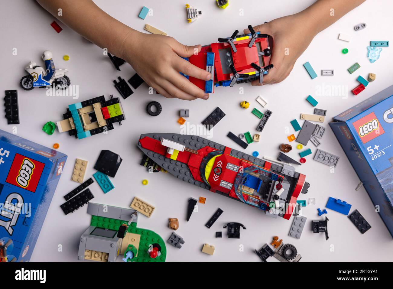 Riga, Lettland - 12. September 2023: Kind spielt mit Lego-Konstrukteur auf dem Tisch. Bau eines Feuerwehrwagens Stockfoto