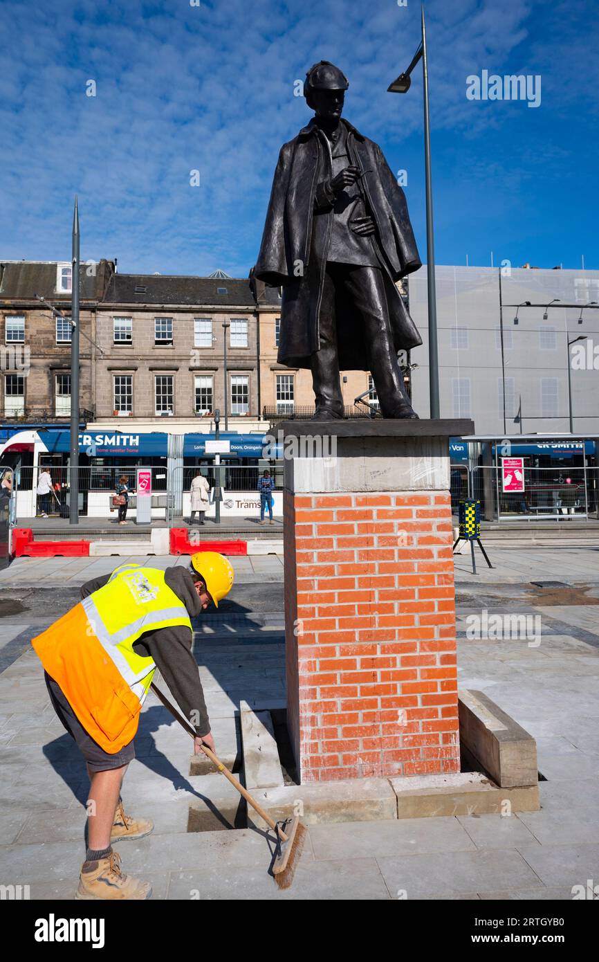 Edinburgh, Schottland, Großbritannien. September 2023. Die neu renovierte Statue von Sherlock Holmes wurde heute von Sir Arthur Conan Doyles Verwandter Tania Henzell und dem Verkehrskonventor Scott Arthur an einem neuen Ort am Picardy Place enthüllt. Die lebensgroße Bronzeskulptur, die den Geburtsort des Schöpfers des Supersleuth, Sir Arthur Conan Doyle, markiert, wurde 2018 entfernt, während Straßenbahnen zu Newhaven-Werken durchgeführt wurden. Es wurde von Black Isle Bronze in Nairn renoviert. Bild: Die Arbeiter machen den Sockel mit der Statue zum letzten Schliff. Iain Masterton/Alamy Live News Stockfoto