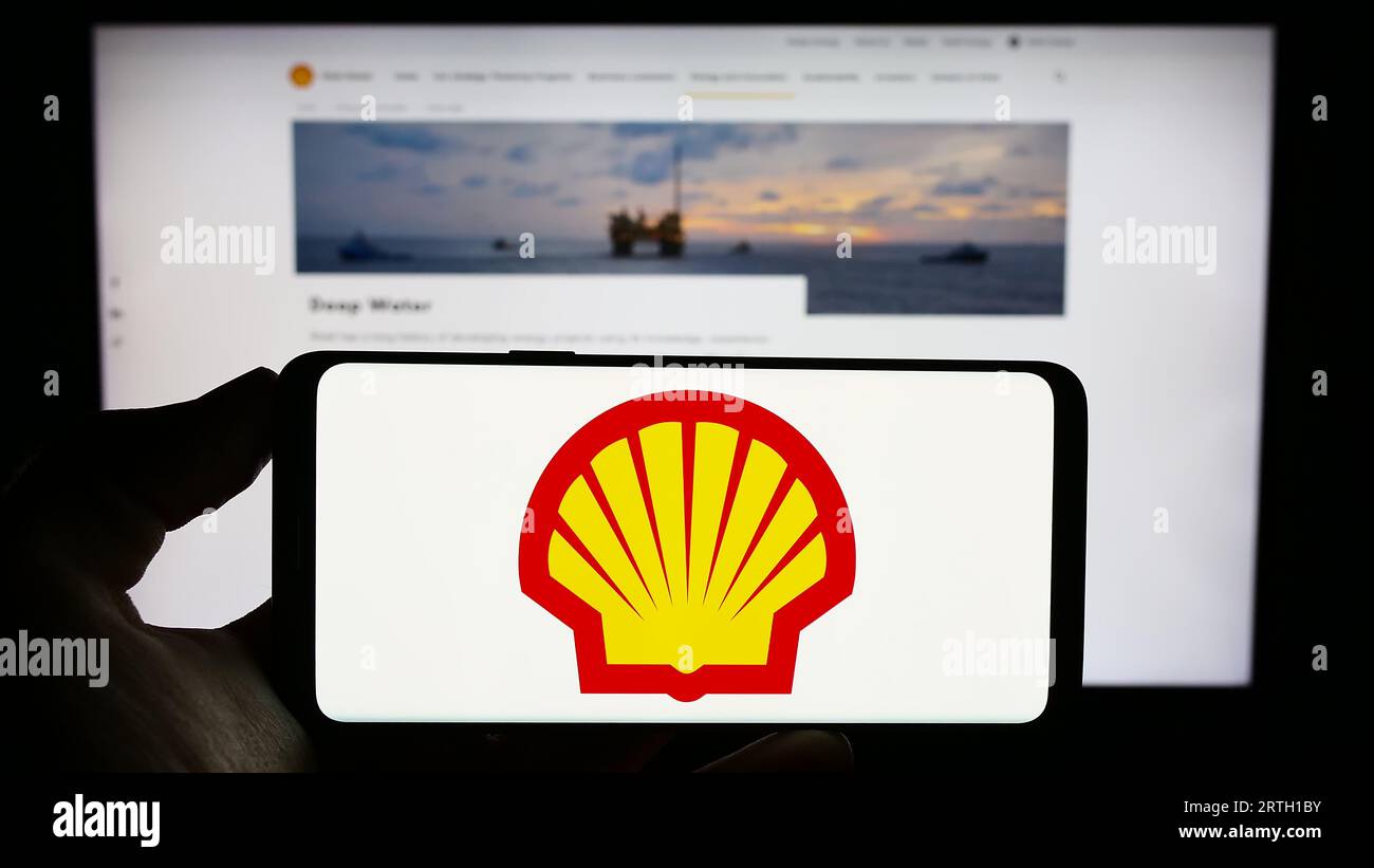 Person, die ein Mobiltelefon mit dem Logo des britischen Öl- und Gasunternehmens Shell plc auf dem Bildschirm vor der Geschäftswebsite hält. Konzentrieren Sie sich auf das Display des Telefons. Stockfoto
