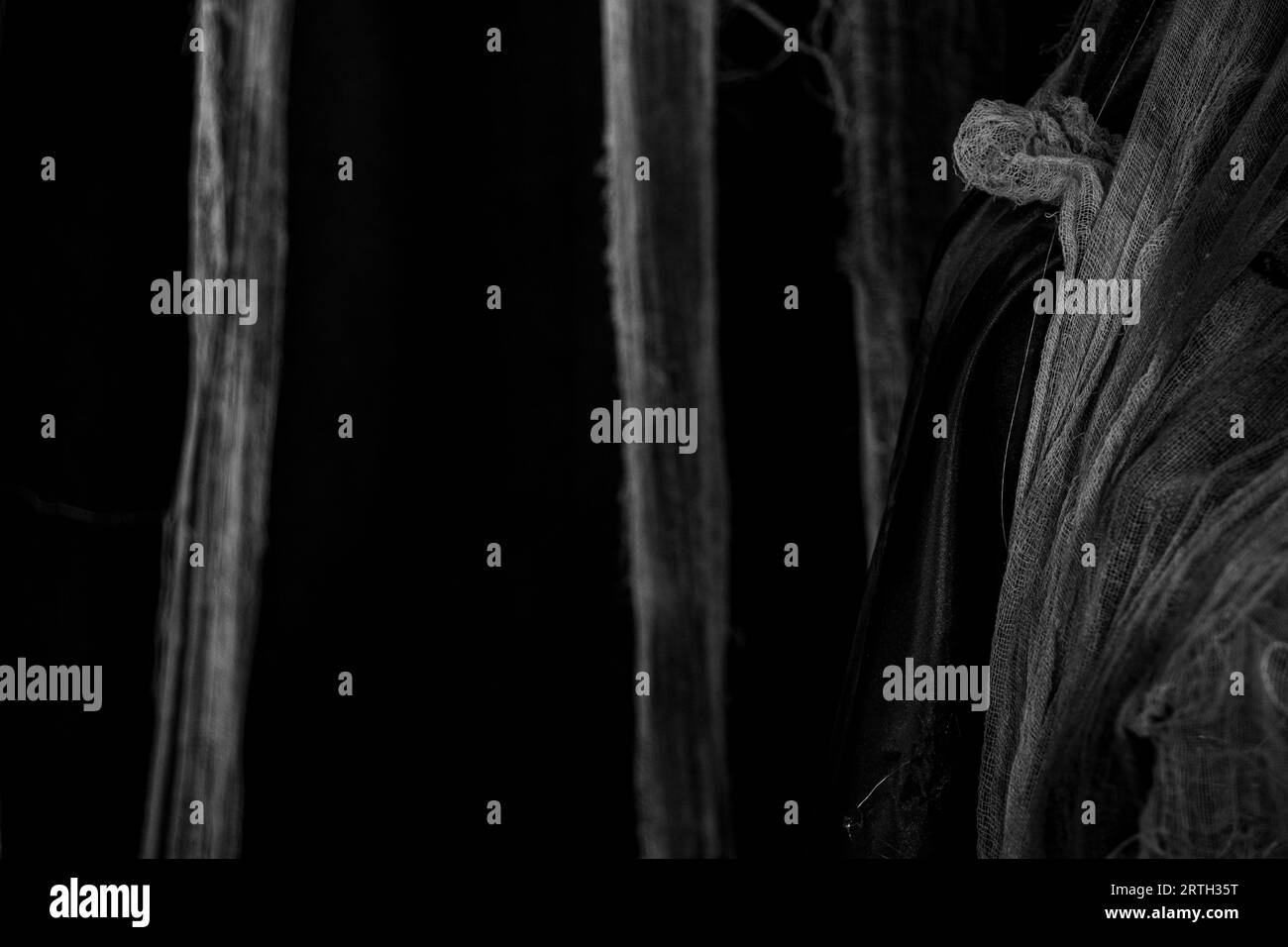 Schwarze Seidenvorhänge und weiße schmutzige Mulltupfer hängen im Dunkeln als Hintergrund, schmutzige gruselige Stoffe als Hintergrund, Dekor und Tapete, dunkler Hintergrund Stockfoto
