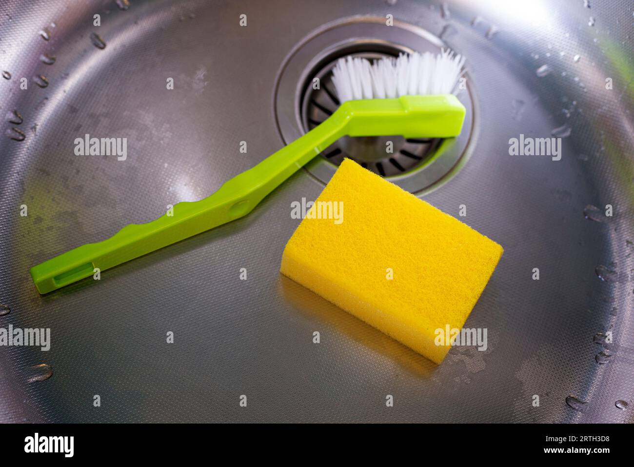 INOX Spülbecken aus Stahl mit Schwamm und Bürste, flach liegend Stockfoto
