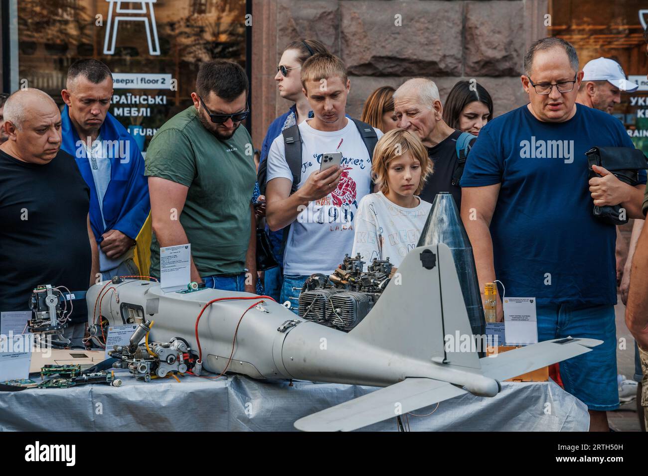 Ein Kind schaut auf die Überreste einer russischen Kamikaze-Drohne, die während der Feier des Unabhängigkeitstages der Ukraine auf der Straße Chreschtschatyk in Kiew ausgestellt ist Stockfoto