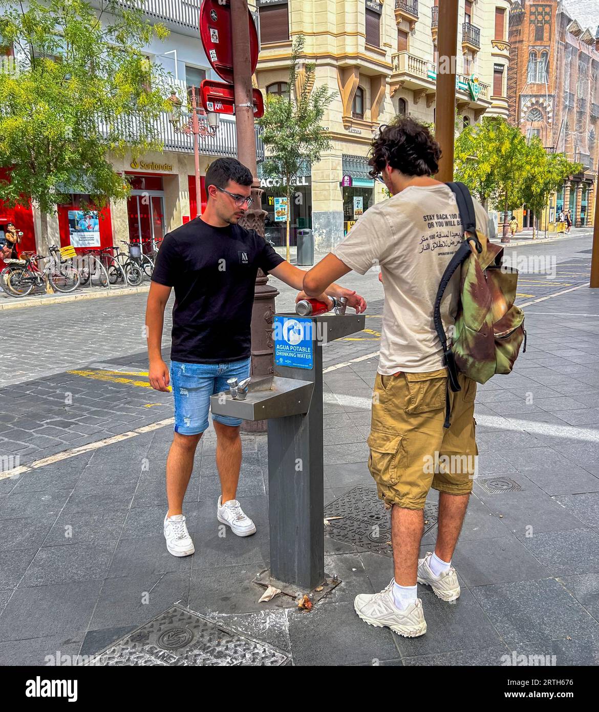 Sevilla, Spanien, Menschen trinken Wasser an heißen Tagen, an der Straßenlandschaft, in der Altstadt, Stockfoto