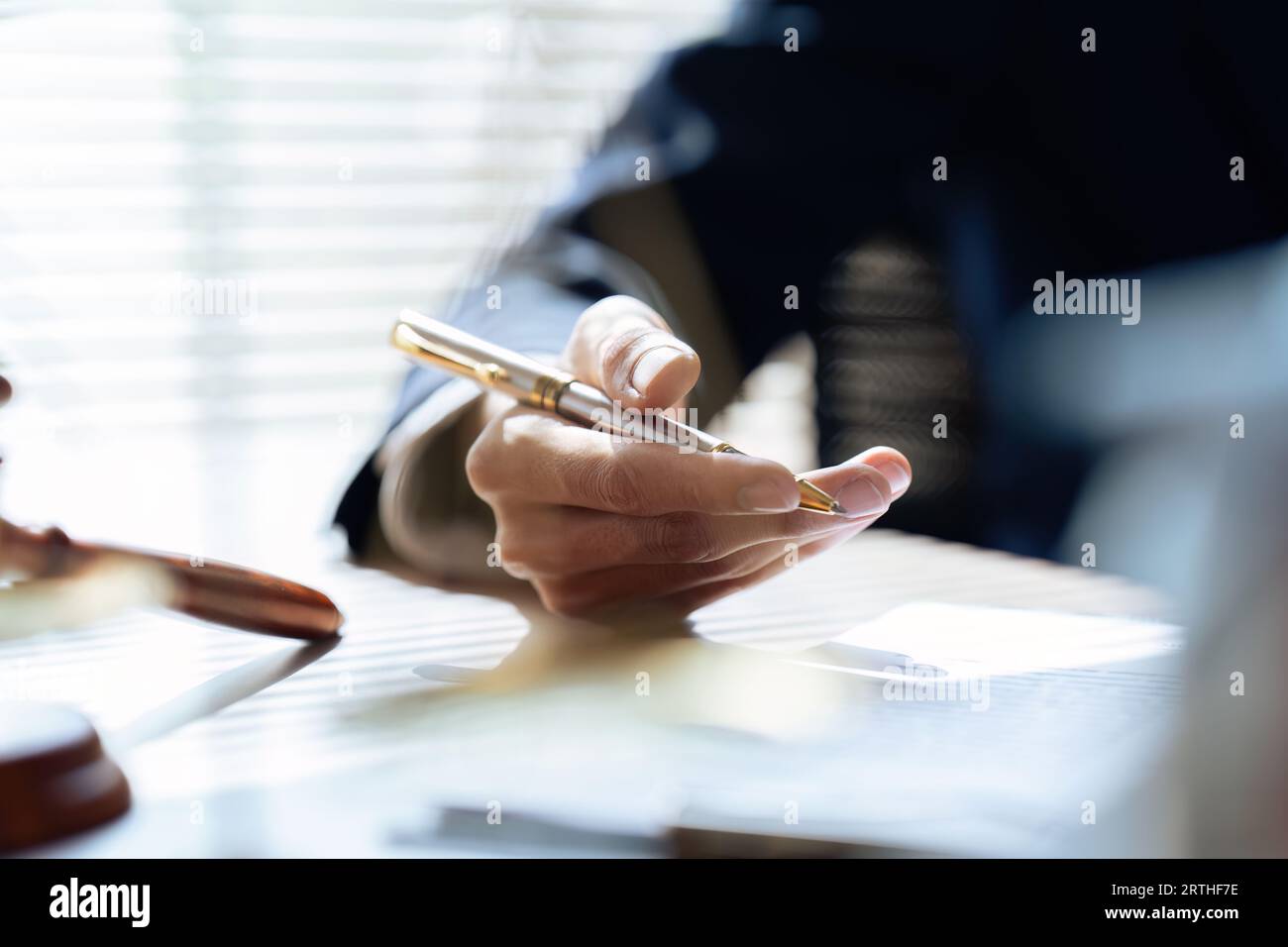 Schließen Sie den Anwalt in der Hand, halten Sie den Stift, unterschreiben Sie das Whitepaper-Formular oder den Antrag, um die Vertragsvereinbarung zu bestätigen und abzuschließen Stockfoto