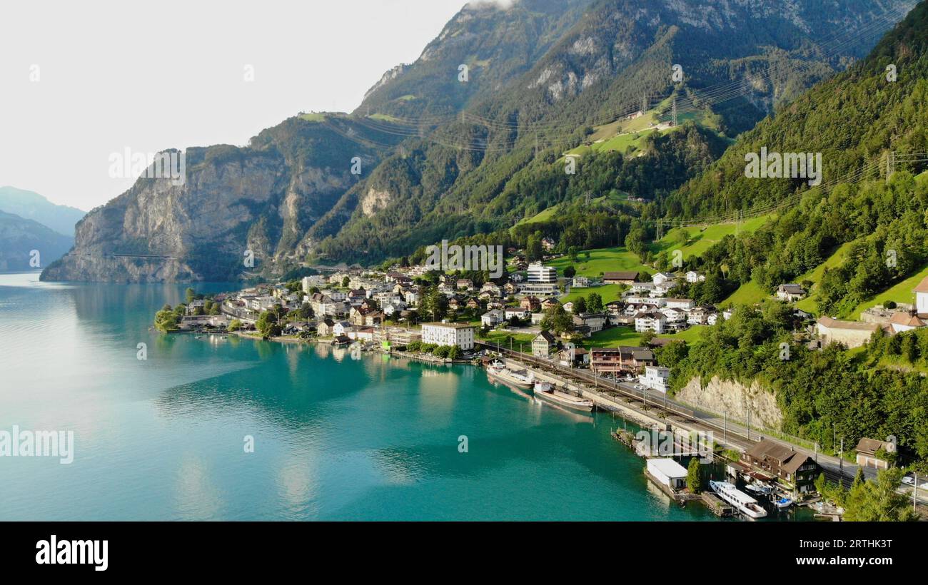 Kleine Stadt namens Fluelen in einem Bergtal mit blauem See Stockfoto