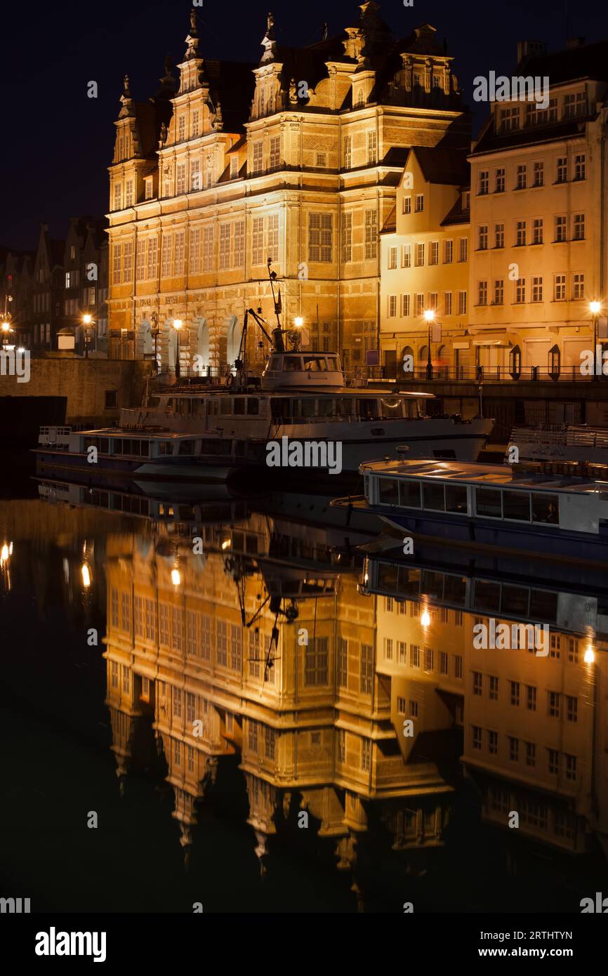 Das Grüne Tor (Polnisch: Zielona Brama) beleuchtet in der Nacht in Danzig, Polen, Wahrzeichen der Stadt, flämische Manierismus Architektur, Reflexion über Motlawa Stockfoto