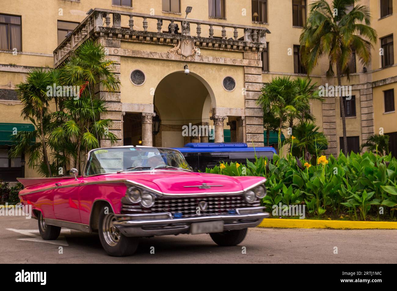 Havanna, Kuba am 13. Januar 2016: Ein roter Oldtimer fährt vor dem berüchtigten Havanas Hotel National, das den Charme der Goldenen 20er Jahre bewahrt Stockfoto
