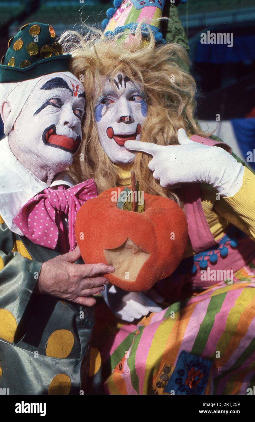 Foto von zwei Ringling Brothers Clowns in vollem Make-up, die einen Kürbis halten, der anscheinend gebissen wurde. Bei den Vorsprechen am Clown College 1979. Stockfoto