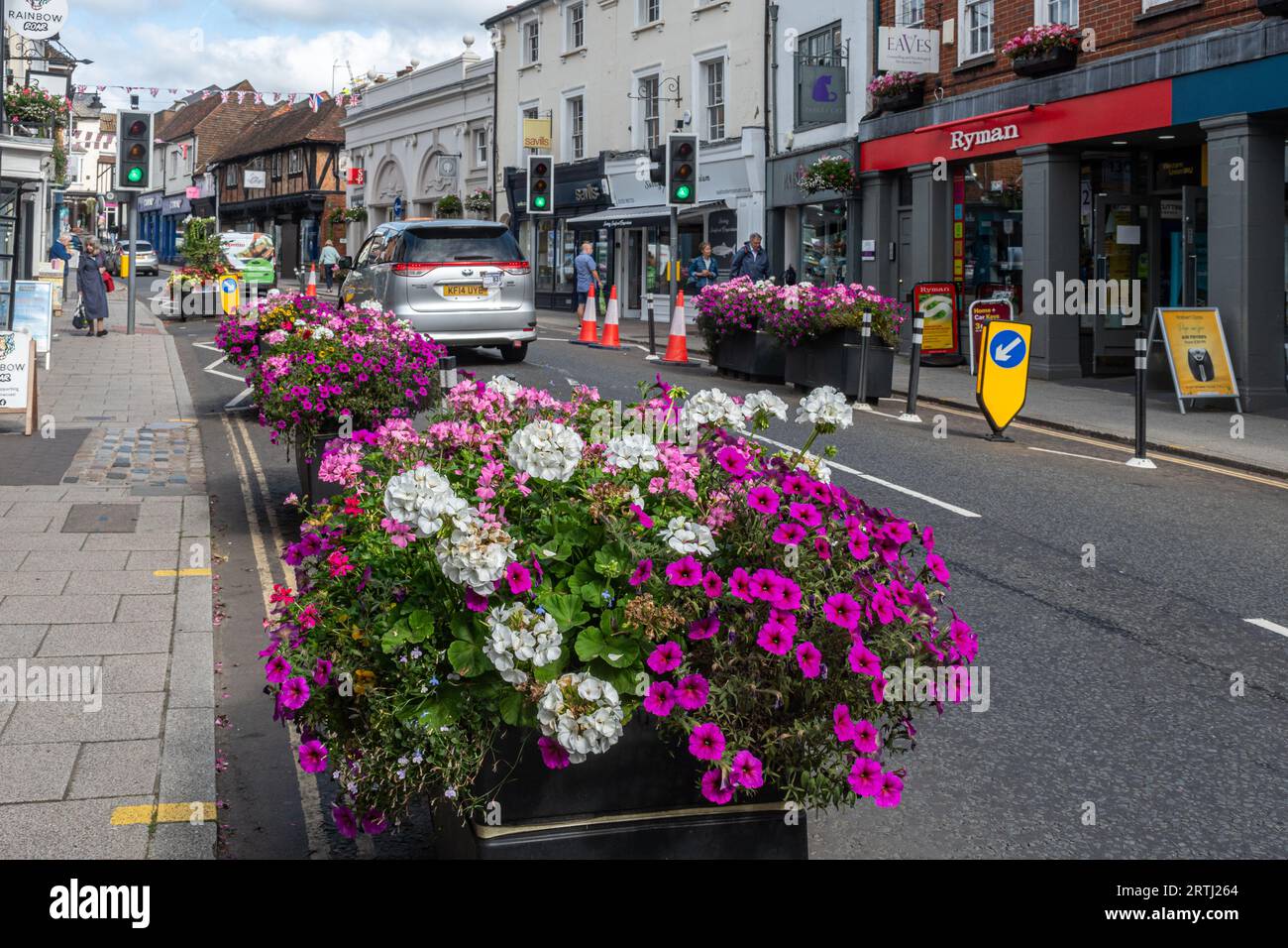 Verkehrsberuhigung, Pflanzgefäße mit Blumen auf der Straße, um sie zu schmälern und langsamer Verkehr, Farnham Stadtzentrum, Surrey, England, Großbritannien Stockfoto