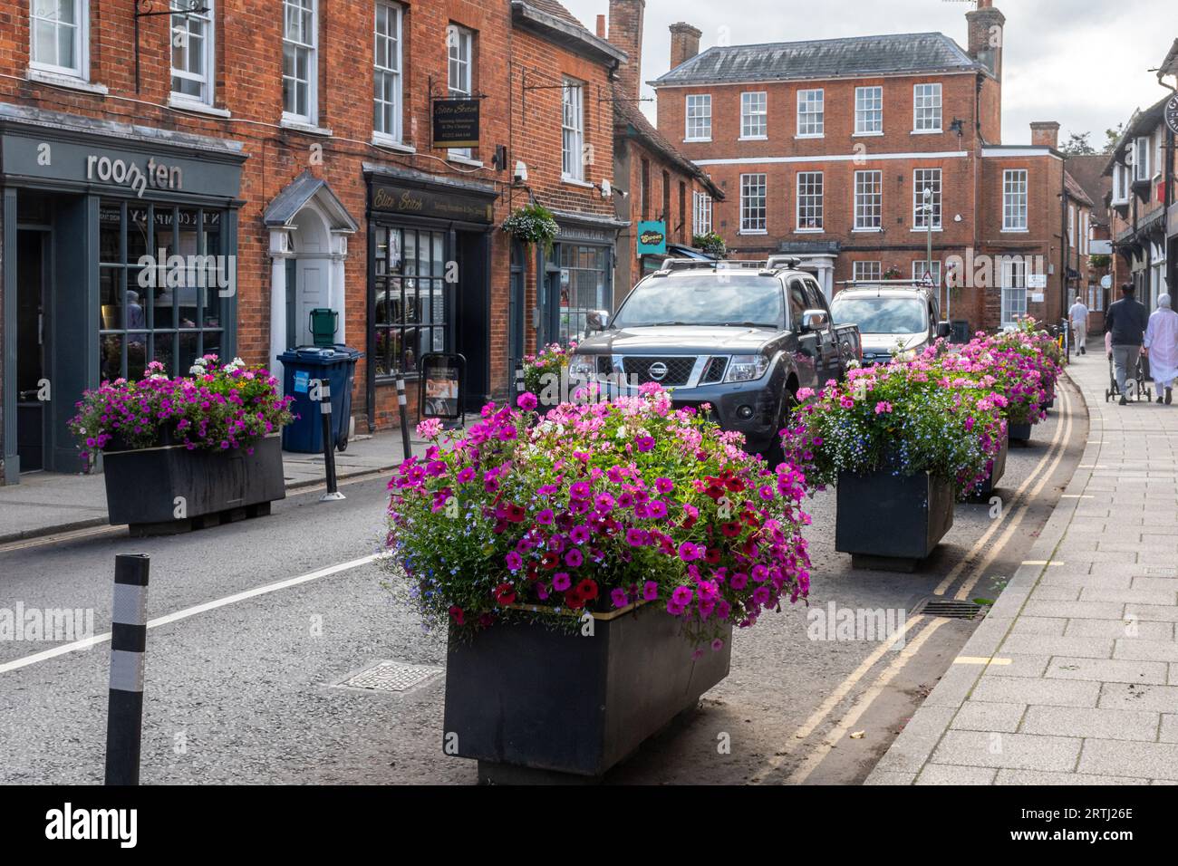 Verkehrsberuhigung, Pflanzgefäße mit Blumen auf der Straße, um sie zu schmälern und langsamer Verkehr, Farnham Stadtzentrum, Surrey, England, Großbritannien Stockfoto