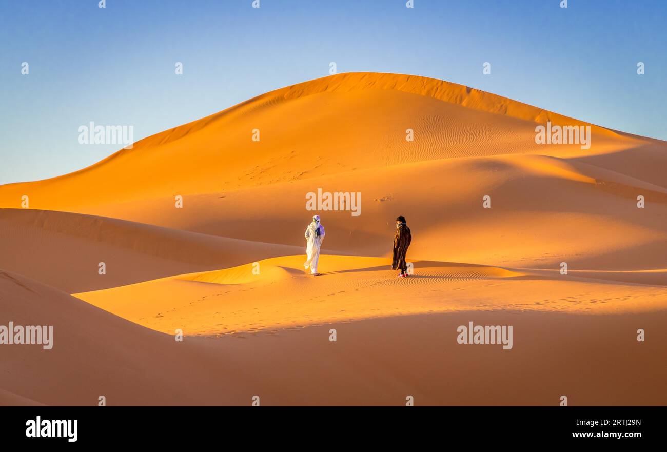 Merzouga, Marokko am 24. Februar 2018: Zwei Berber in der orangefarbenen Sahara, Merzouga, Marokko Stockfoto